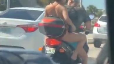 Woman shaves legs on moped